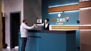 A reception desk with a sign that reads "SECRET Hotel." - SECRET HOTEL (Baku)