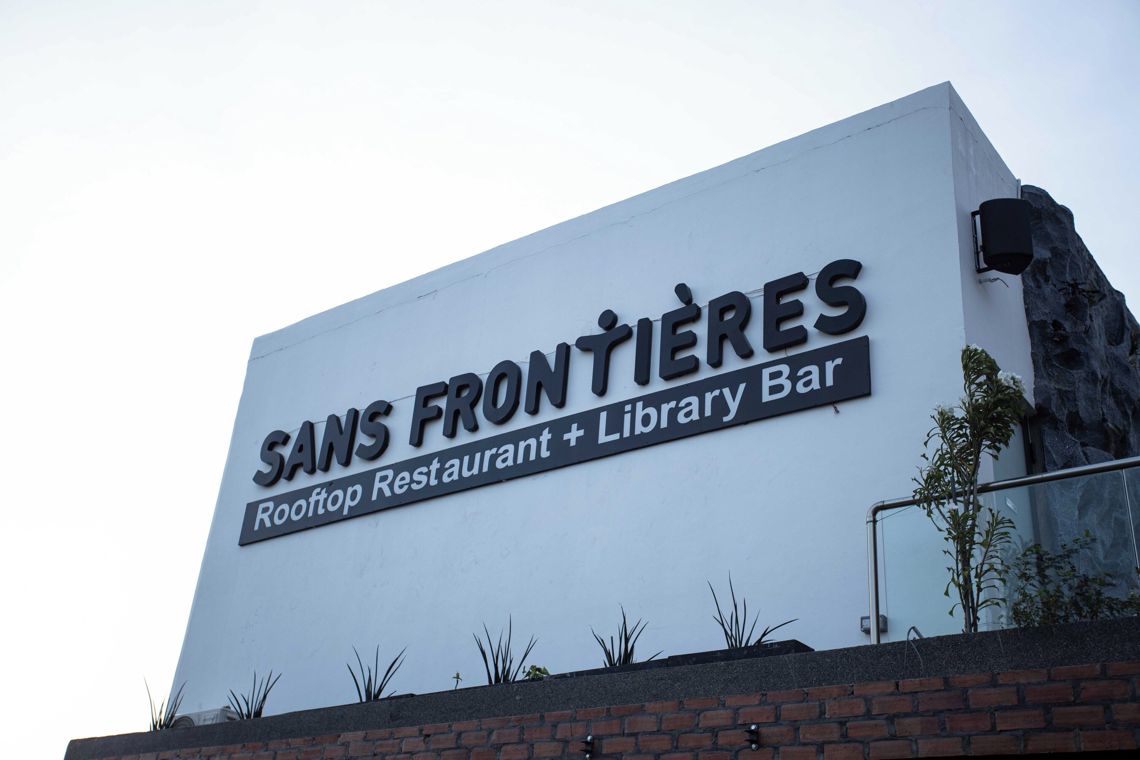 Un edificio con un letrero que dice 'Sans Frontières Rooftop Restaurant + Library Bar'.