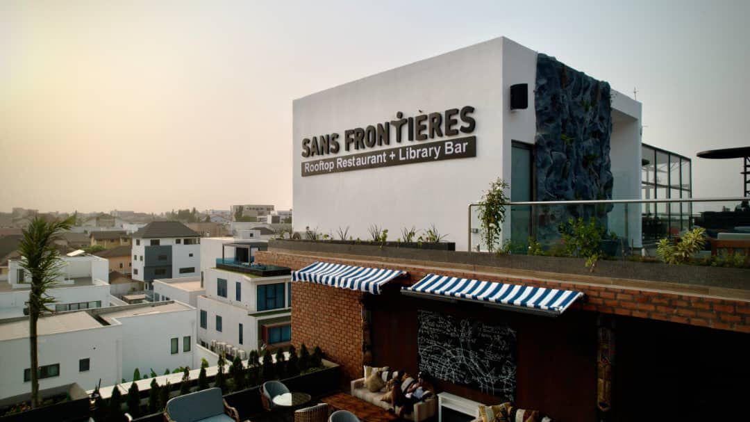 A rooftop bar with a sign for 'Sans Frontières Rooftop Restaurant + Library Bar'.
