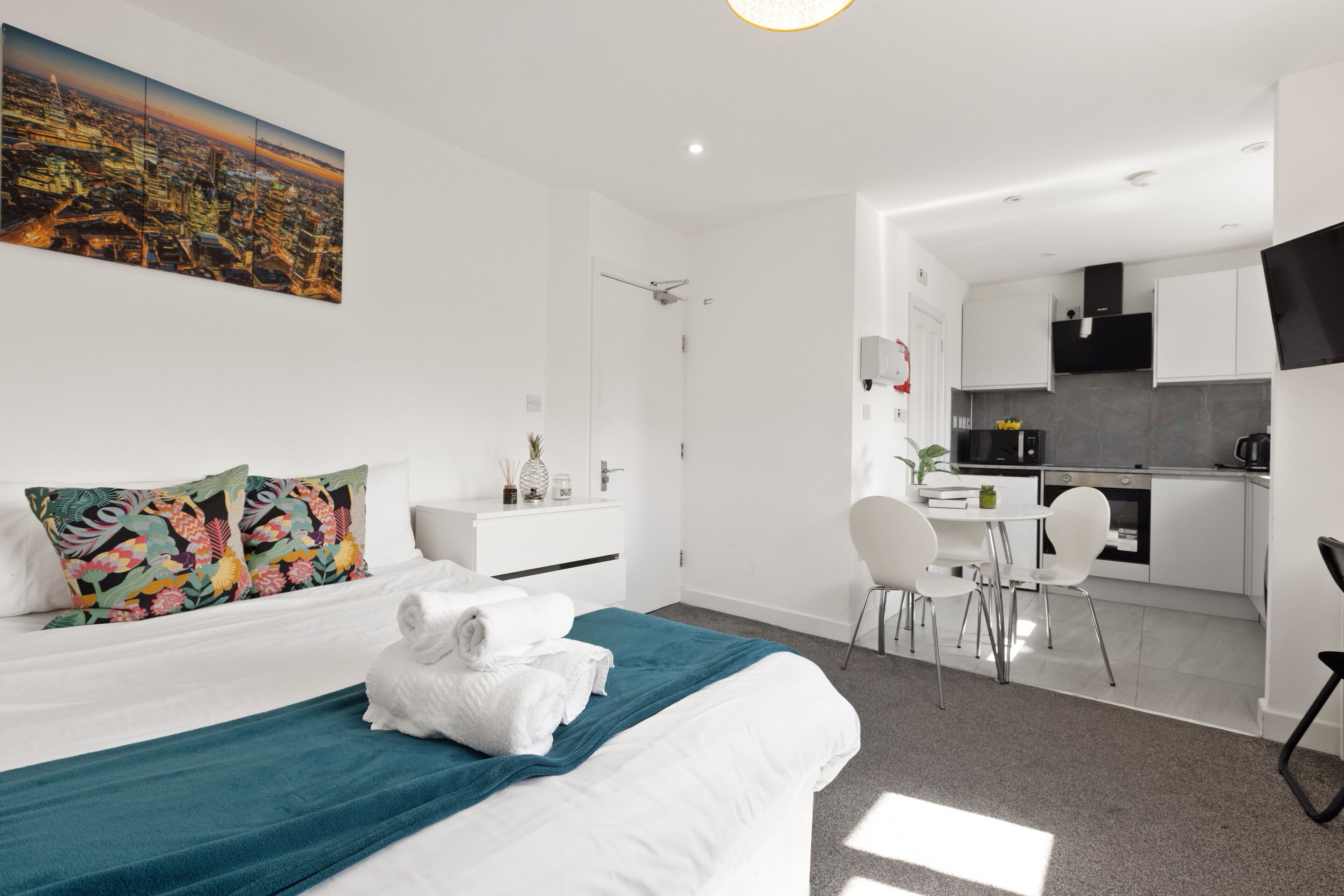 Une chambre d’hôtel moderne équipée d’un lit, d’un bureau et d’une kitchenette.