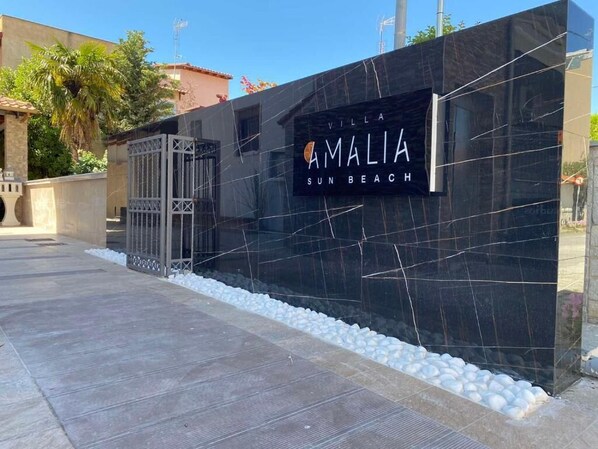 A black marble wall with the sign "Villa Amalia Sun Beach".
