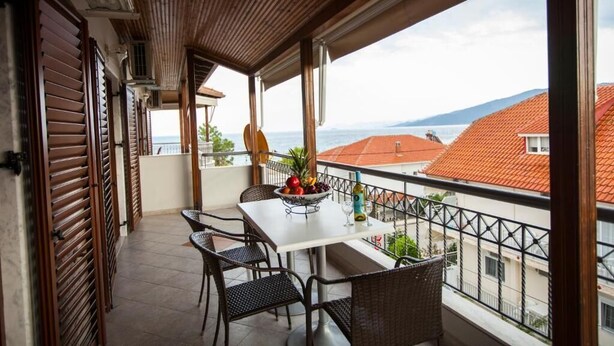 A balcony with a table, chairs, and a fruit bowl. - Villa Amalia Sun Beach (Volvi)