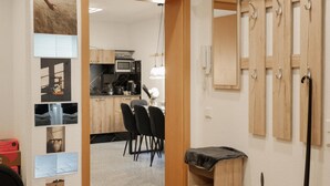 Une cuisine moderne avec un coin repas, des meubles en bois et une chaise noire.