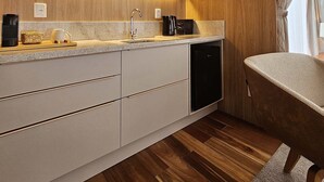 Een moderne keuken met houten kastjes, een ingebouwde magnetron en een koffieapparaat.