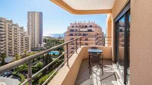 A balcony with a table and chairs, overlooking a pool and other buildings. - 05 -b902 in Portim o (Portimão)