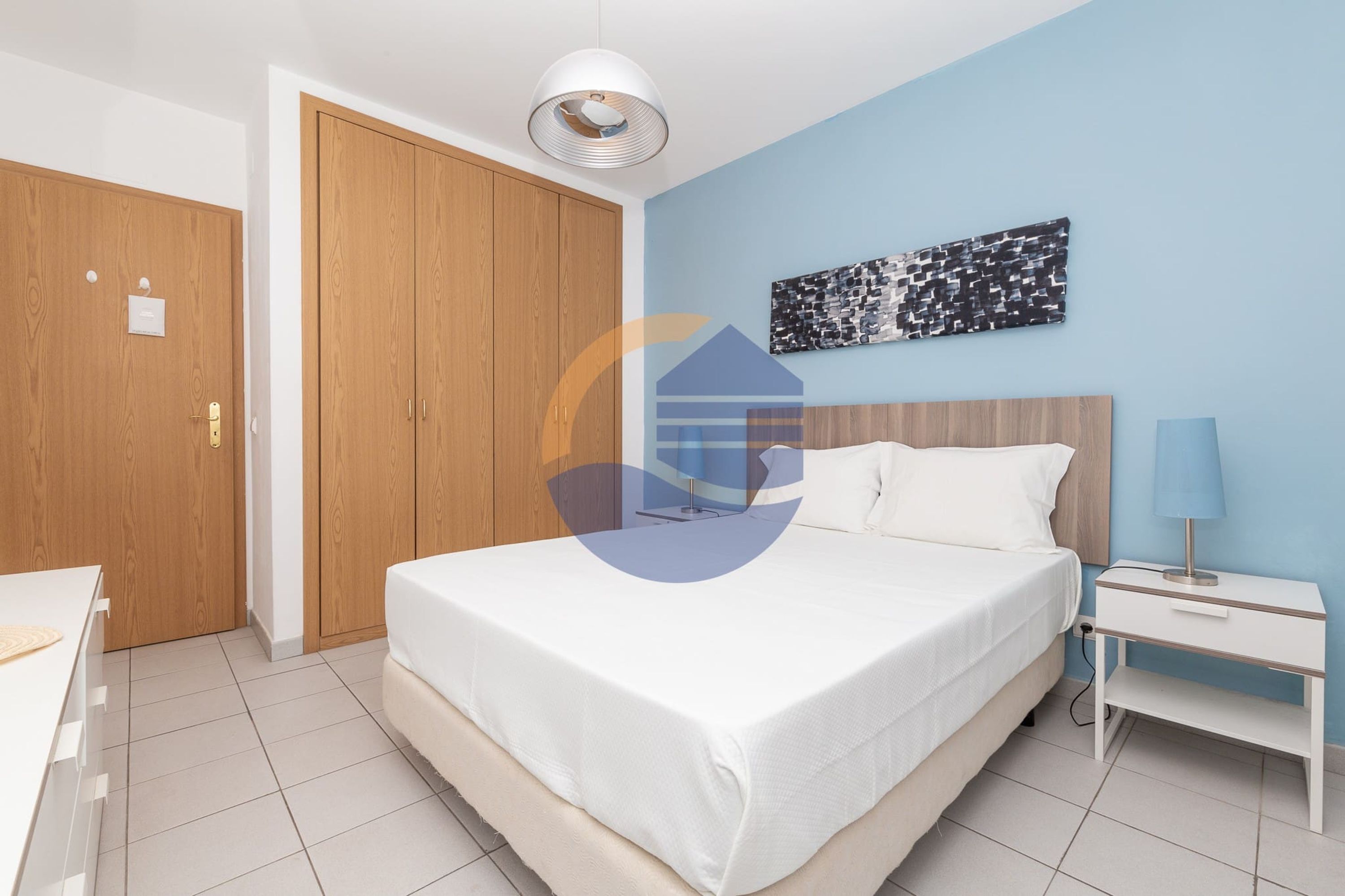 Ein Schlafzimmer mit Bett, Nachttisch und Kleiderschrank.