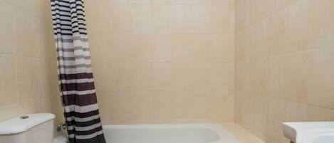 A bathroom with a bathtub, toilet, and bidet.