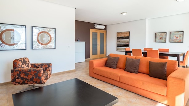 A modern living room with a sofa, a coffee table, and a dining area with chairs and a table. - 23 - A607 in Portim o (Portimão)