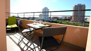A balcony with a table, chairs, and a view of buildings. - 09 - B707 in Portim o (Portimão)
