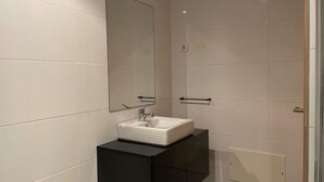 A modern bathroom with a white sink, a large mirror, and a black vanity. - 13 - B315 in Portim o (Portimão)