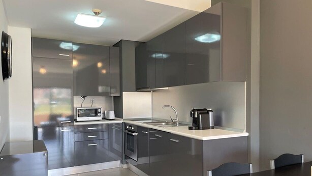 A modern kitchen with stainless steel appliances, a built-in oven, and a coffee maker on the countertop. - 13 - B315 in Portim o (Portimão)