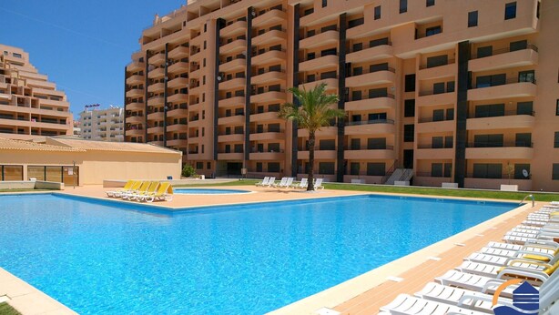A swimming pool with lounge chairs and a building in the background. - 16 - B709 in Portim o (Portimão)