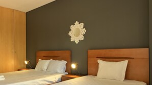A hotel room with two beds, a wooden wardrobe, and a decorative mirror on the wall. - 01 - B206 in Portim o (Portimão)