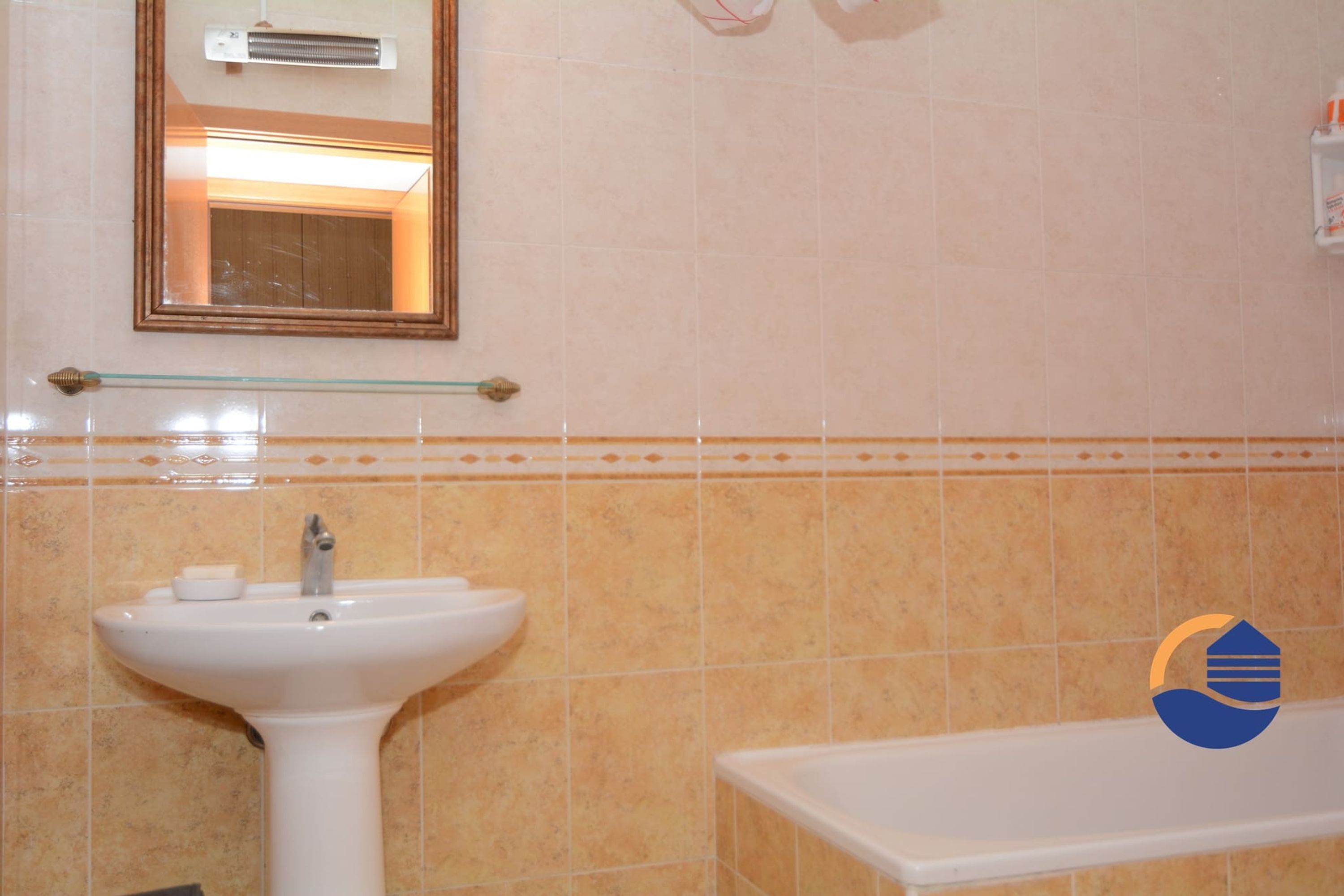 A bathroom with a pedestal sink, a mirror, and a bathtub.