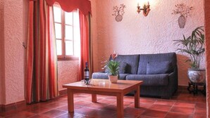 Ein Wohnzimmer mit einer Couch, einem Couchtisch und einer Zimmerpflanze.