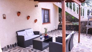 Eine möblierte Terrasse mit Sofa, Stühlen und Tisch.