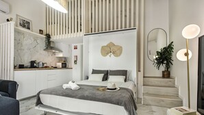 A modern bedroom with a bed, bedside tables, a desk, and a staircase. - Alca Arias Suite 20 (Faro)