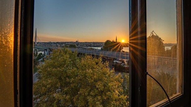 A sunset view through a window, featuring a bridge and a distant cityscape. - The Han Residence Halic Hotel (Istanbul)