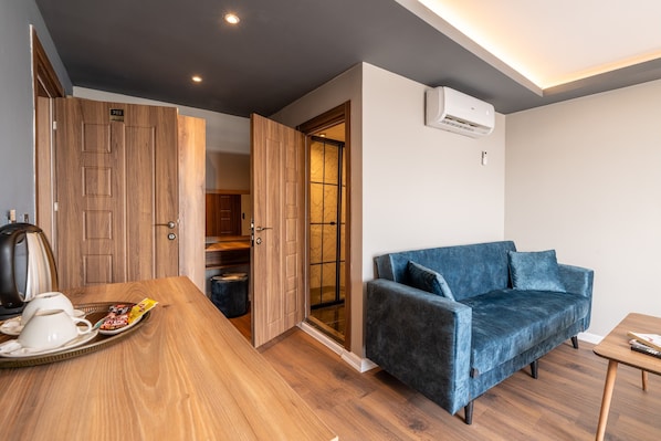 A modern room with a wooden dining table, a blue sofa, and a wooden wardrobe. - The Han Residence Halic Hotel (Istanbul)