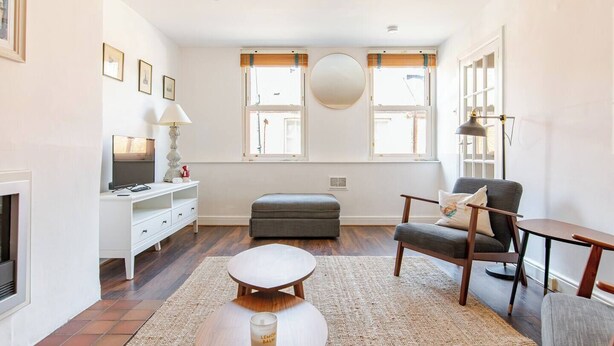 En moderne stue med pejs, fjernsyn, sofa og sofabord.