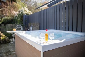 A hot tub with a bottle and two glasses on a white surface. - Auberge Le Florida Gascony (Castera-Verduzan)