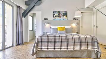 Una camera da letto con un letto grande, una lampada moderna e un quadro appeso al muro.
