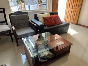 Guests can relax in this inviting living room with a coffee table, armchair, and sofa.
