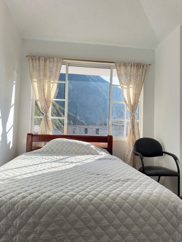 Relax in this serene room with a large bed and stunning mountain views.