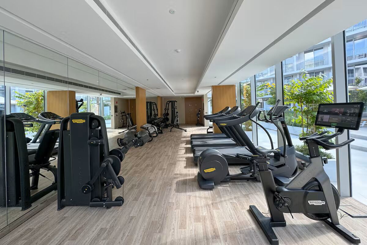 Ett gym med konditionsmaskiner, styrketräningsmaskiner och en digital skärm.