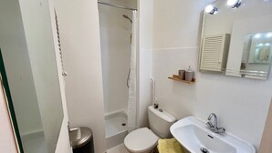 A bathroom with a shower, toilet, sink, and a mirror. - 5 min to Parc des Princes • Studio 18 m²<br>Boulogne (Boulogne-Billancourt)