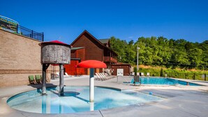 Ein Poolbereich mit einer Holzdiele, Liegestühlen und wolkenlosem, blauem Himmel.