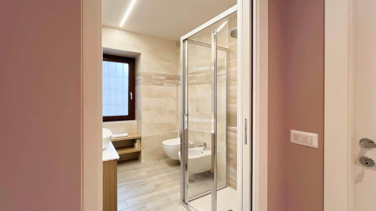 Ein modernes Badezimmer mit Duschkabine aus Glas, Toilette und Waschbecken.