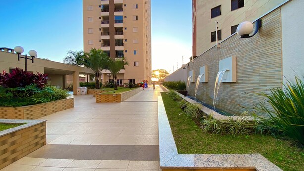 A modern residential building with a central courtyard, a water feature, and a playground.