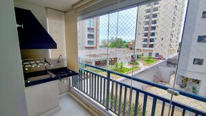 A balcony with a view of a residential area, a small sink, and a ventilation hood.