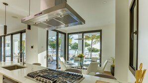 Una cocina moderna con una isla grande, electrodomésticos de acero inoxidable y vistas al exterior.