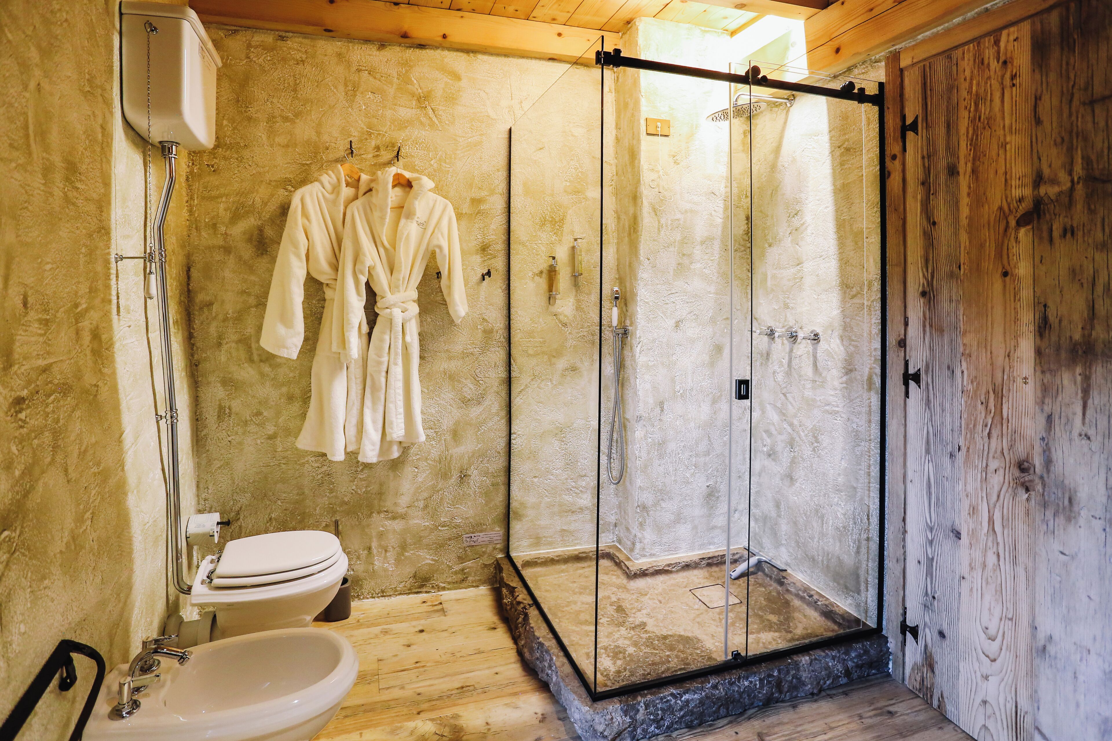 A bathroom with a glass-enclosed shower, a white toilet, and a sink.