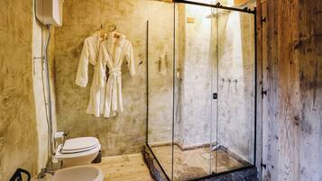 A bathroom with a glass-enclosed shower, a white toilet, and a sink.