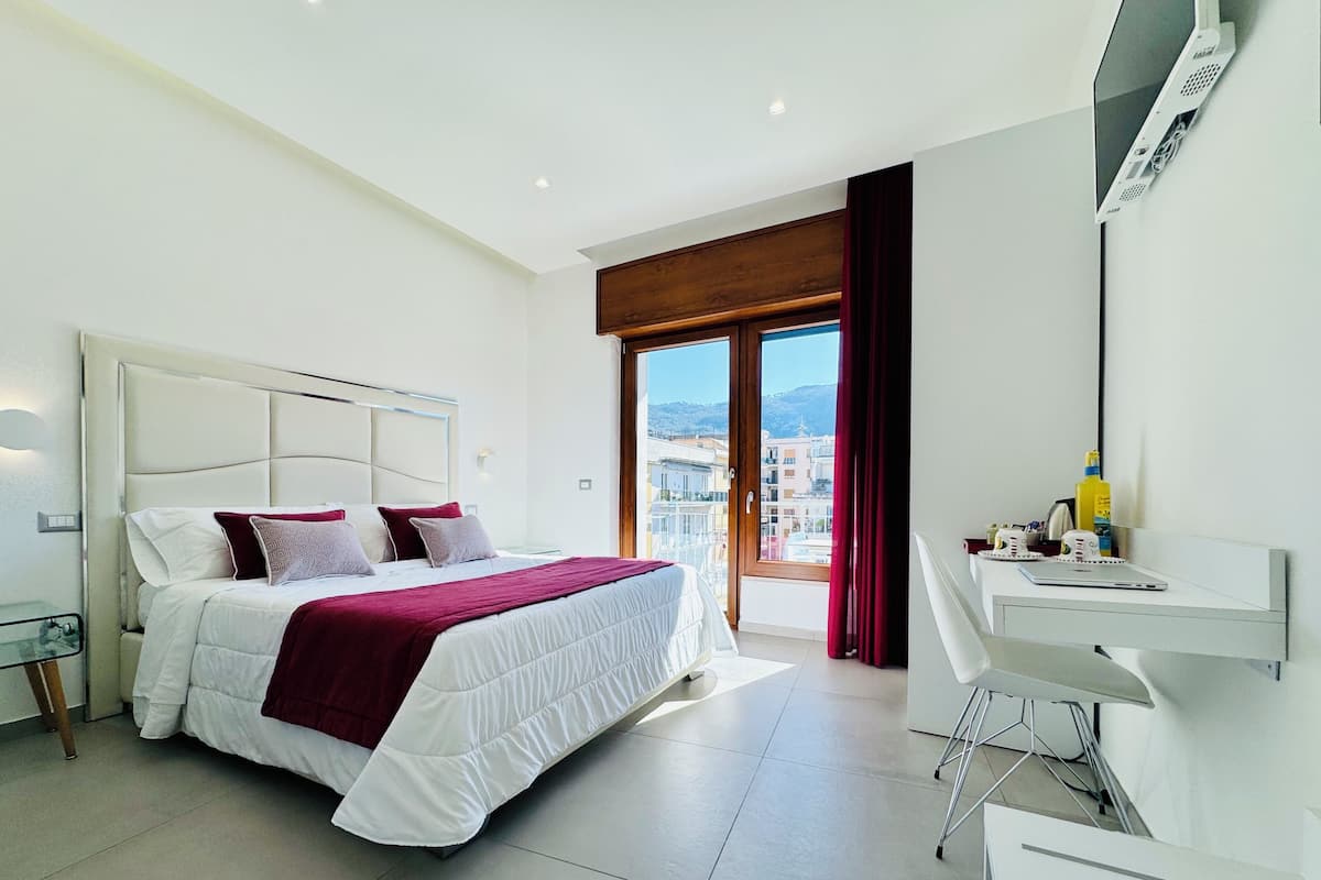 Une chambre d’hôtel moderne avec un grand lit, un bureau et une vue sur la ville.