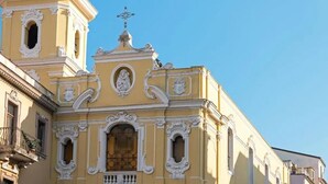 A yellow building with ornate architectural details, including a bell tower and statues. - Vera Gioia Rooms de Charme (Sorrento)
