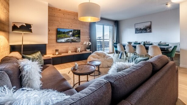 A modern living room with a sofa, a coffee table, and a fireplace.