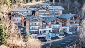A multi-story lodge with a central courtyard, balconies, and a parking area.