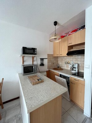 A compact kitchen with a microwave, toaster, and coffee maker.