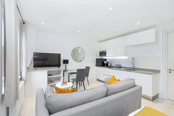 A modern apartment with a living room, dining area, and kitchen. - Stylish Studio Retreat in Trendy Marylebone (London)