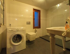 Een kleine badkamer met een wasmachine, toilet en wastafel.
