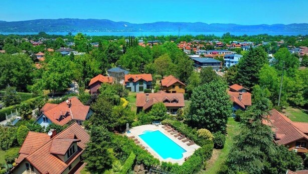 Zona residencial com casas, piscina e um lago ao fundo.