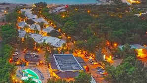 Vista aerea di un resort con diversi edifici, una piscina e un’area parcheggio.