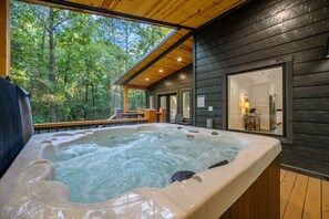 A hot tub in a wooden cabin with a view of the forest. - Romantic,Spacious,Modern Cabin | Hot Tub! (Broken Bow)