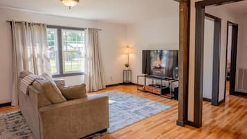 A living room with a sofa, a TV, and a fireplace.