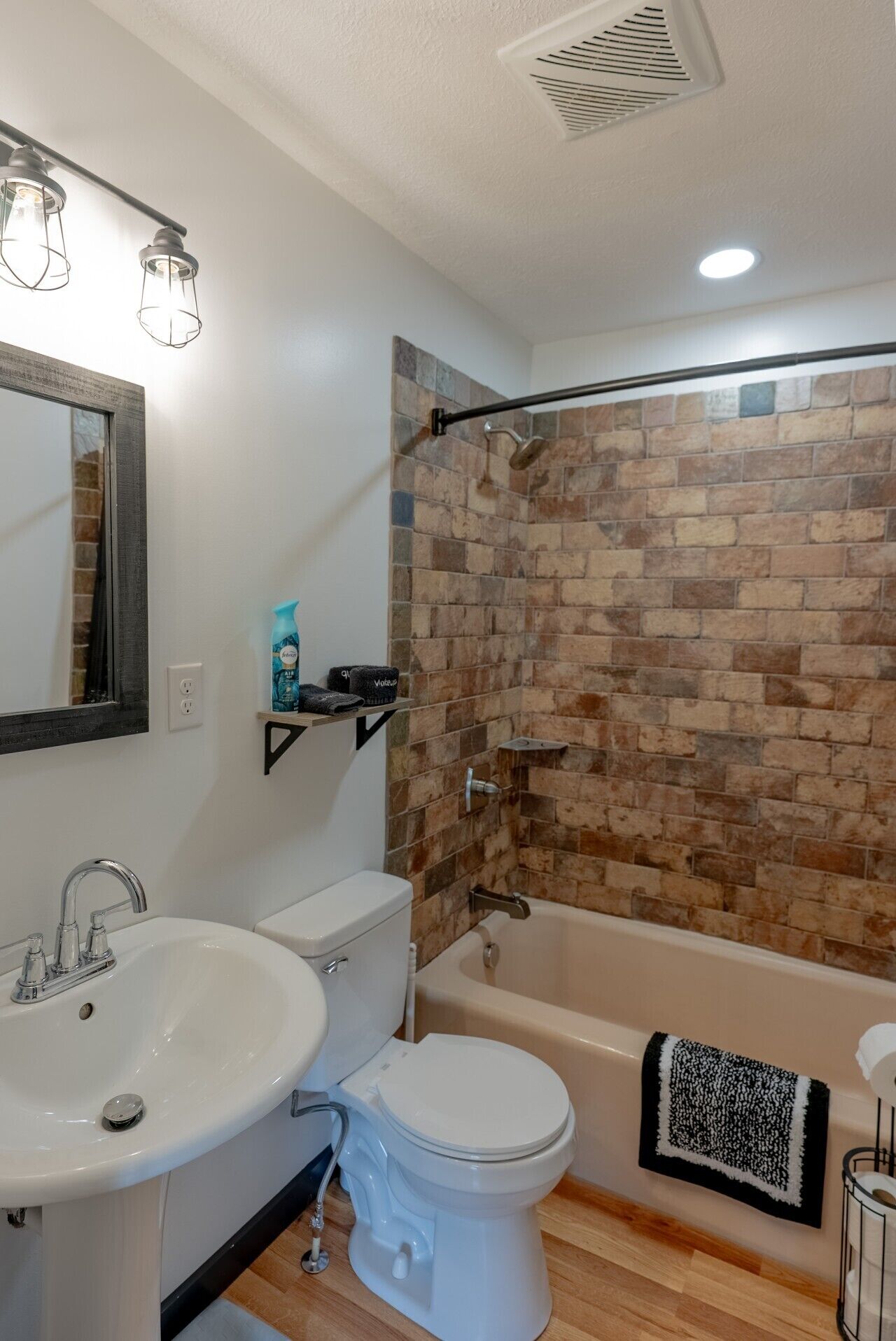 Un baño moderno con lavamanos, inodoro y bañera blancos.