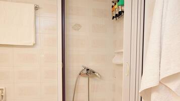 Een douche, handdoeken, zeep, shampoo